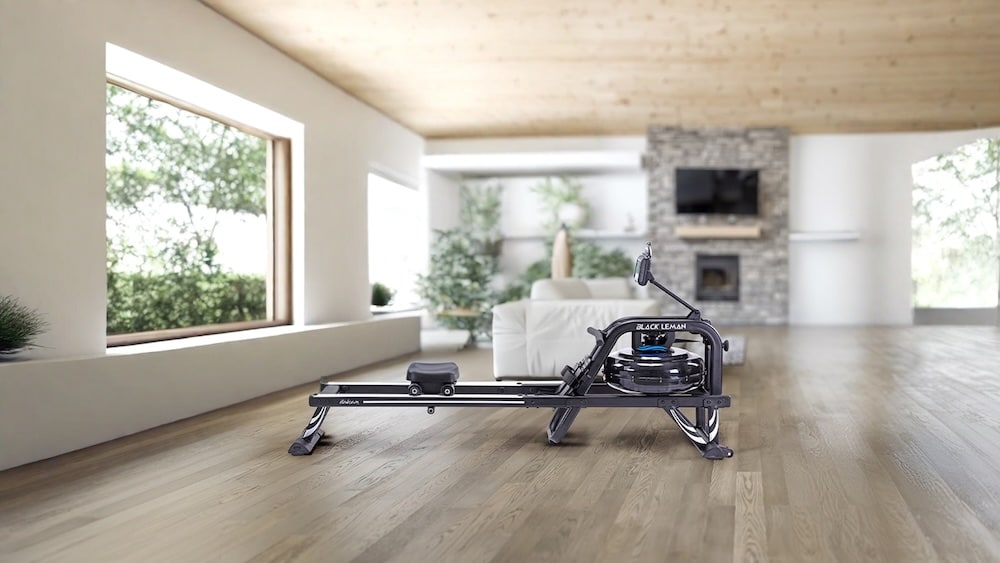 Rameur Heubozen de couleur noire placé sur un sol en bois dans un espace intérieur.